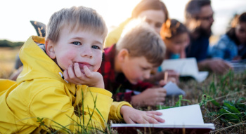 students sitting in the grass during a field trip